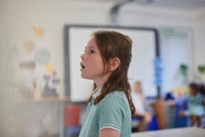 Bambina in classe durante un’attività orale