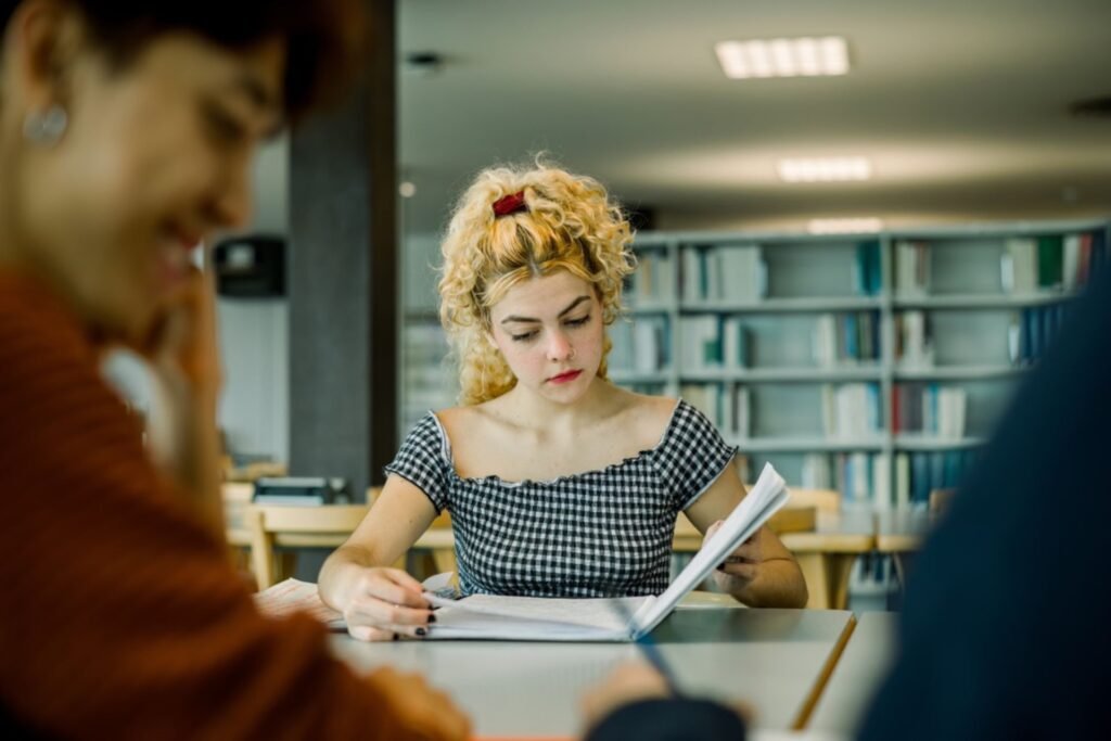 Ragazza concentrata che studia in biblioteca