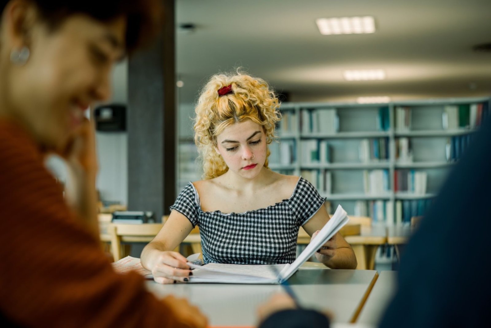 Ragazza concentrata che studia in biblioteca